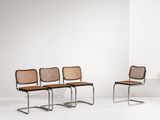 quatre chaises dans une pièce blanche aux murs blancs et au sol blanc