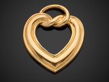 a gold heart pendant with a knot in the middle