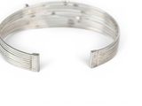 a close up of a metal bracelet on a white surface