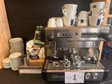 a coffee machine sitting on a counter with cups on it