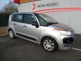 La petite voiture argentée est garée devant un immeuble.