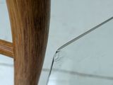 a close up of a wooden chair with a glass seat