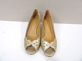 pair of women ' s gold shoes on a white surface