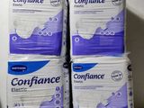 quatre paquets de serviettes hygiéniques sont empilés les uns sur les autres