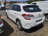 a small white car parked in a lot with other cars