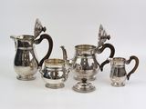 four pieces of silver tea and coffee set on a white background