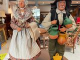 two figurines of a man and a woman standing on top of a table