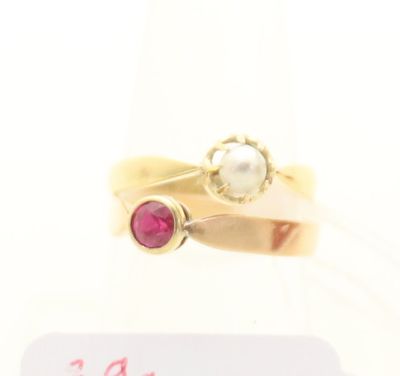 un gros plan d'une bague en or sertie d'une perle et d'un rubis