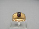 une image représentant une bague en or sertie d'un grenat