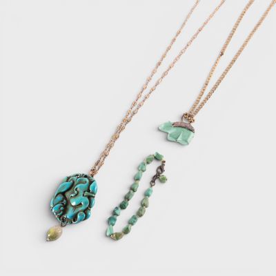 three necklaces with turquoise and green beads on a white background