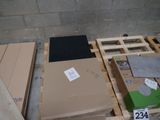 une pile de cartons posée sur une palette près d'un mur
