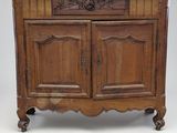 une vieille armoire en bois avec un plateau sculpté et deux portes