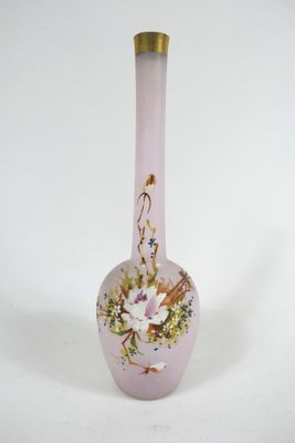 un vase en verre rose orné de fleurs, posé sur une surface blanche
