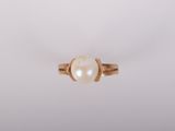 une bague en or avec une perle au centre