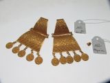 deux paires de boucles d'oreilles en or et une étiquette de prix posée sur une table