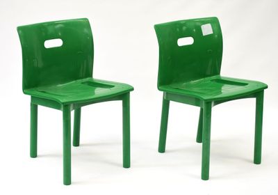 une paire de chaises d'école en plastique vert sur fond blanc