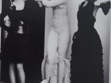black and white photograph of two women standing in front of a statue