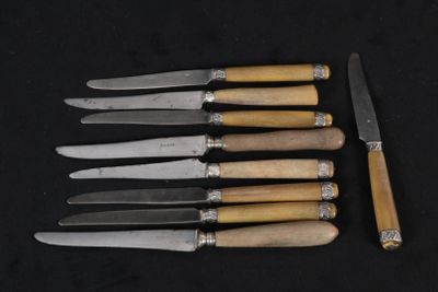 six couteaux sont alignés sur une surface noire, avec un couteau au milieu