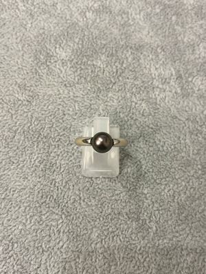 un gros plan d'une bague ornée d'une perle noire