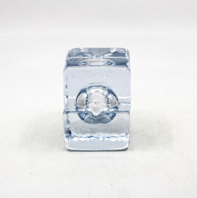 un glaçon percé d'un trou posé sur une surface blanche