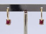 pair of ruby and diamond hoop earrings on a gold plated stand