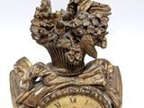 a gold clock with a bird on top of it
