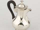 a silver coffee pot with a wooden handle on a white surface