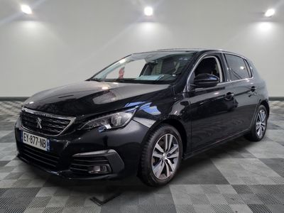 La voiture noire est garée sur un sol en dalles à damier.