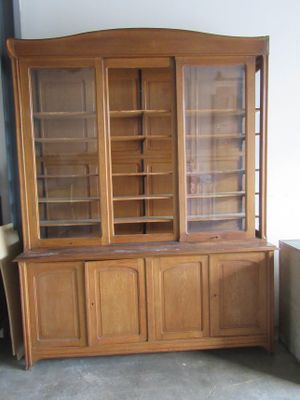 un vaisselier en bois avec des portes en verre dans une pièce
