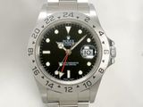 a rolex watch with a black dial and red second hand