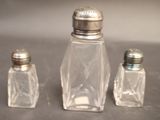 three salt and pepper shakers sitting on a table