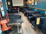 des tables et des chaises dans un restaurant aux murs bleus et au parquet