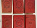 six red books are lined up in a row on a table