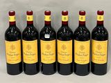 six bottles of red wine lined up in a row on a table