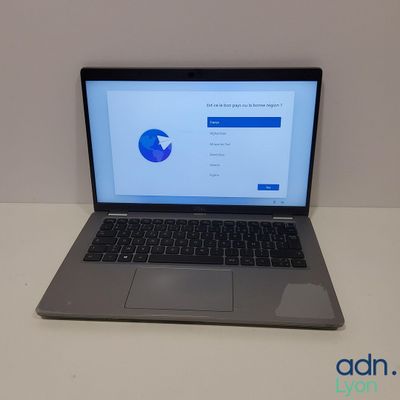 un ordinateur portable ouvert posé sur une table blanche
