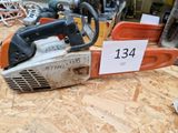 une tronçonneuse posée sur un plancher en contreplaqué