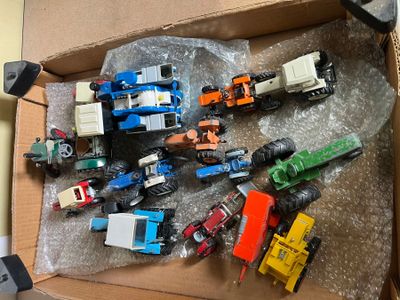 a lot of toy vehicles in a box on the floor