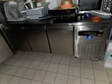 une cuisine équipée d'une cuisinière, d'un évier et d'autres éléments posés sur le plan de travail