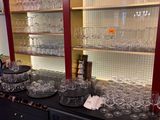 bottles and glasses are lined up on a bar in a wine cellar