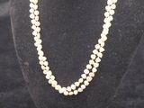 a white pearl necklace on a mannequin with a gold clasp