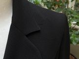 a female mannequin wearing a black jacket and a pink and white manicure