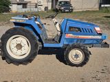 a blue tractor that is parked in the dirt