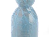 un vase bleu posé sur une surface blanche