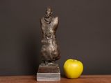 a statue of a man and an apple on a table