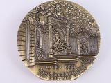 a gold medal with a picture of a fountain
