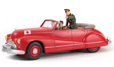 a figurine of a man in a red car on a white background