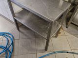 a metal table with a blue hose next to it