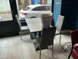 a table and chairs in a room with a car in the background