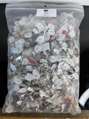 a bag full of silver and white buttons on a table