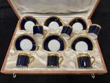 un service de six tasses et soucoupes bleues et blanches, présenté dans une boîte